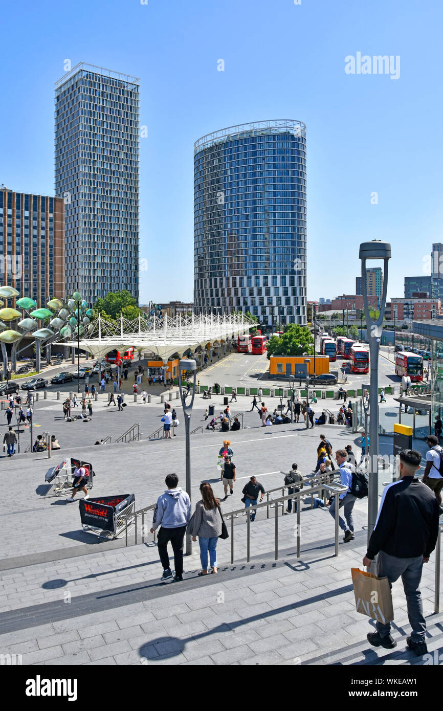 Passi verso il basso dei mezzi di trasporto pubblico bus e stazione ferroviaria concourse alto grattacielo apartment building & office block Stratford East skyline di Londra REGNO UNITO Foto Stock