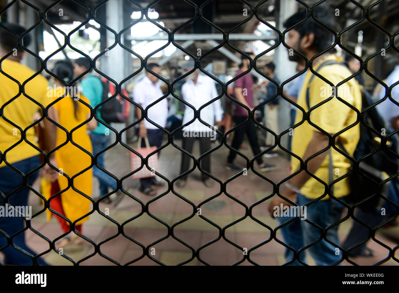 INDIA, Mumbai, stazione ferroviaria suburbana di treno pendolari Western Railway WR, viaggio pendolari tra suburbani e centro città, vista dalla finestra del treno bloccato, molti passeggeri sulla piattaforma Foto Stock