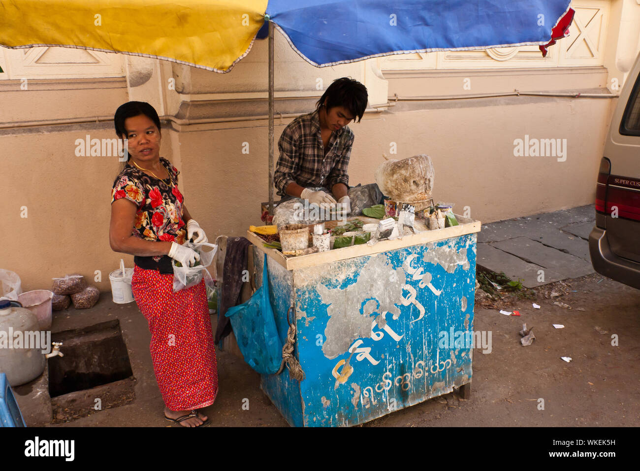 Una giovane coppia la preparazione e vendita di betel sulla strada di Yangon Foto Stock