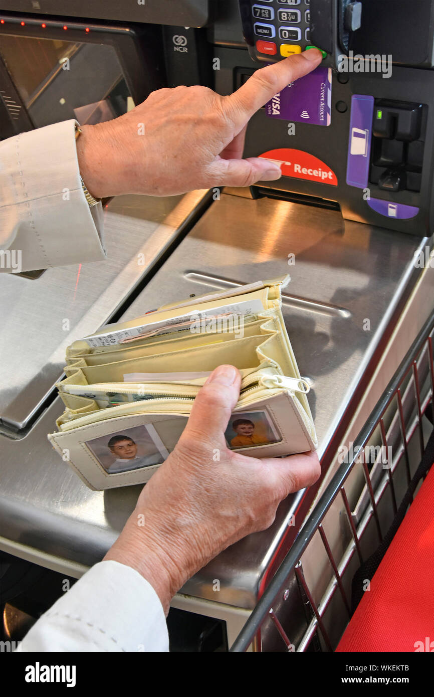 Aprire la borsetta detenute da donna per accedere a una carta di debito per pagare la spesa alimentare bill supermercato Tesco self service acquista fino a kids foto signor Londra Inghilterra REGNO UNITO Foto Stock