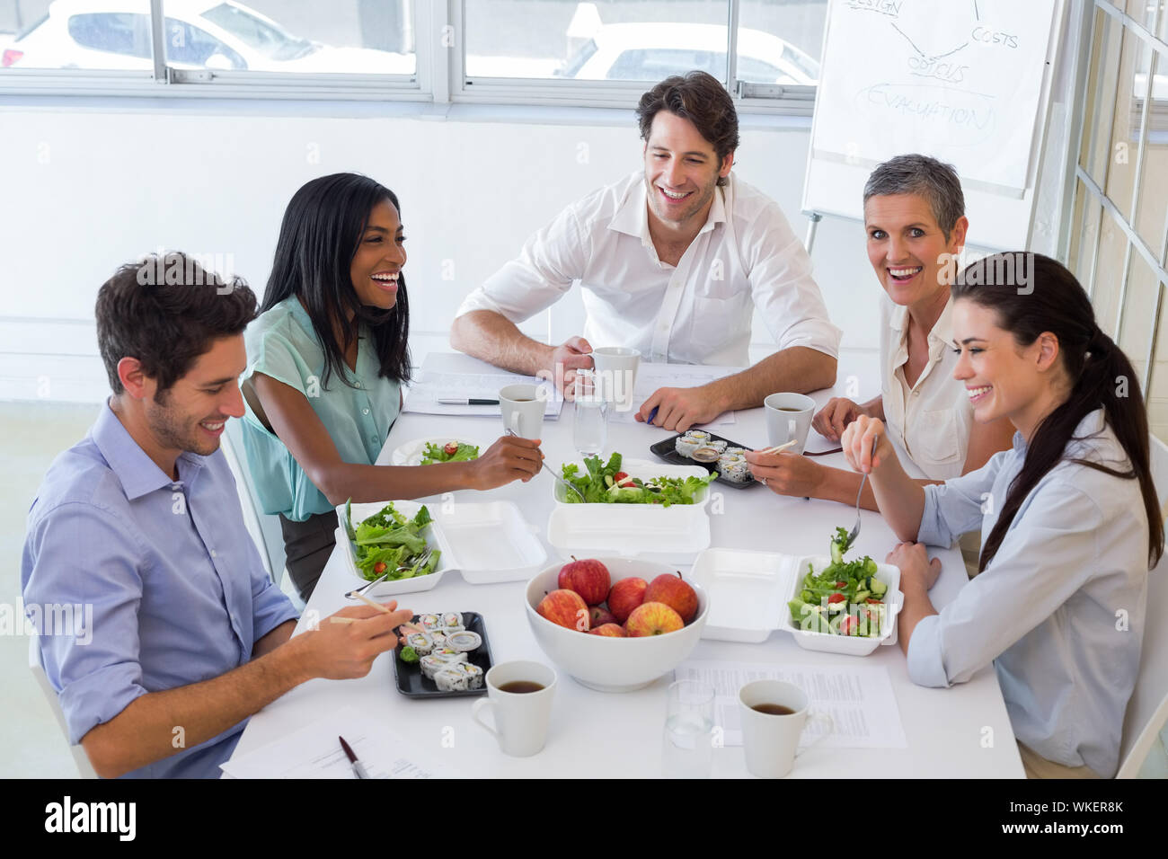 I lavoratori di ridere mentre godendo la pausa pranzo in ufficio Foto Stock