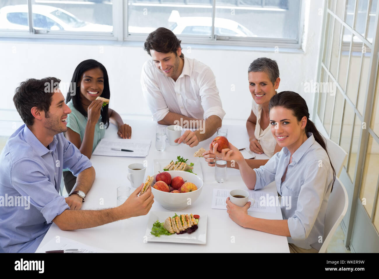 Lavoratori godendo di panini per pranzo in ufficio Foto Stock