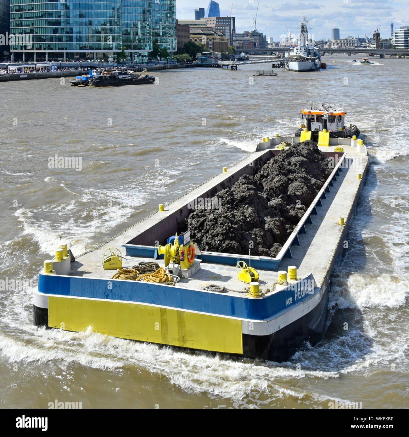 Vista da sopra le lunghe barge e carico del terreno di scavo del fiume Thames Tideway Tunnel progetto Fognature spinto lungo il fiume dal rimorchiatore Londra Inghilterra REGNO UNITO Foto Stock