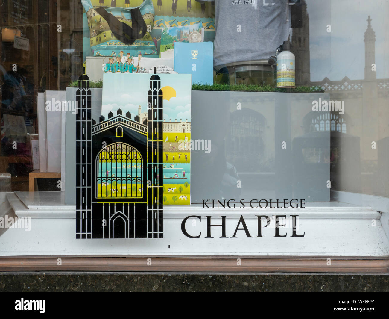 Il Kings College Chapel riflettendo nella finestra del Kings College Chapel shop in Kings Parade Cambridge Regno Unito che vende souvenir turistici Foto Stock