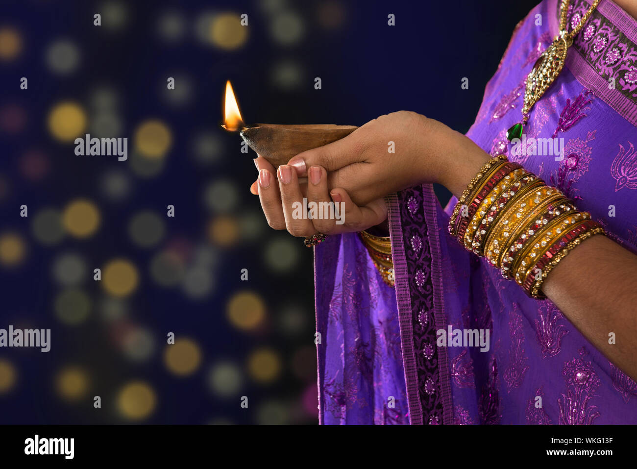 Diwali o festosa di luci. Tradizionale festa indiana, donna in sari mani  olio lampada, con luce di sfocatura dello sfondo Foto stock - Alamy