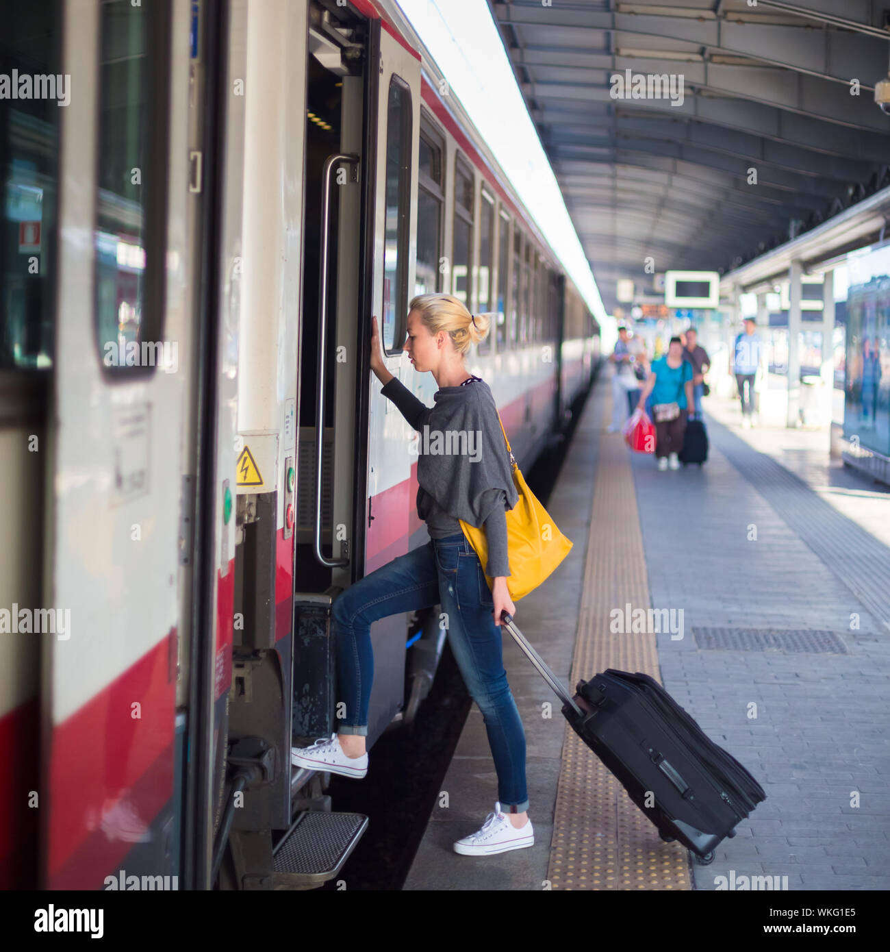 Signora in attesa presso la stazione ferroviaria. Foto Stock