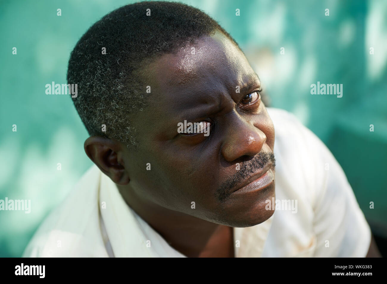 Ritratto di metà di età african american uomo seduto in posizione di parcheggio e guardando la telecamera con espressione triste Foto Stock