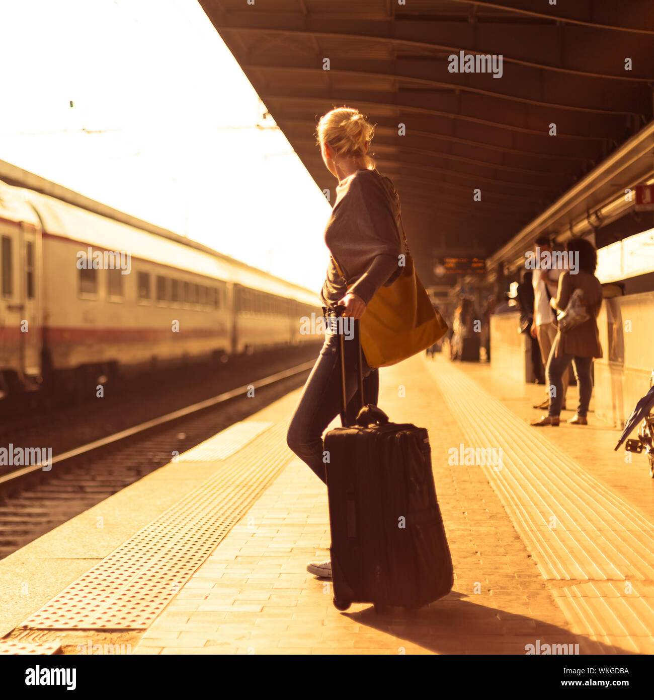 Signora in attesa presso la stazione ferroviaria. Foto Stock