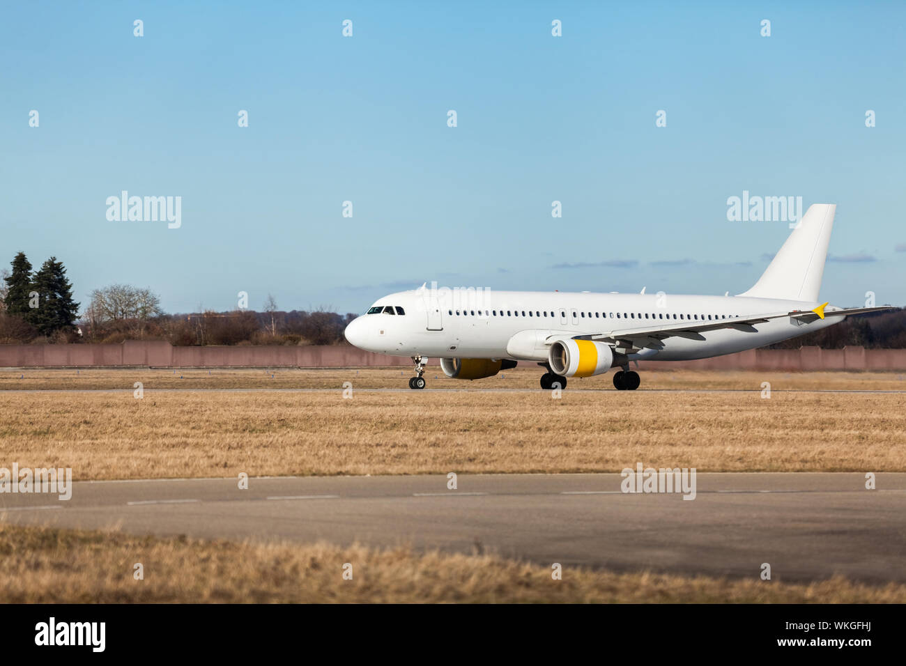 Aereo di linea di passeggeri di decollare in un aeroporto chiaro di sollevamento della pista di fronte al terminal, vista laterale Foto Stock