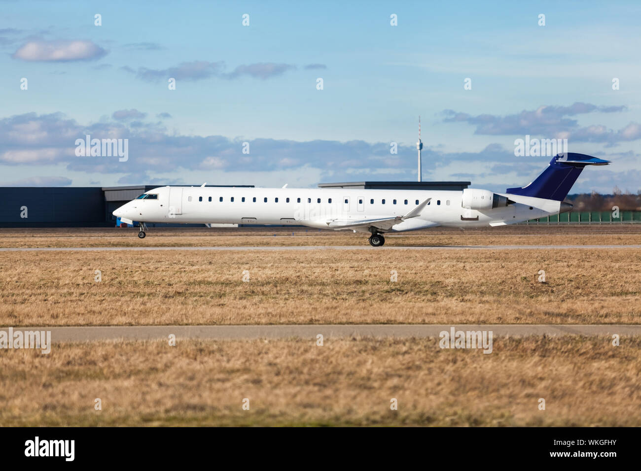 Aereo di linea di passeggeri di decollare in un aeroporto chiaro di sollevamento della pista di fronte al terminal, vista laterale Foto Stock