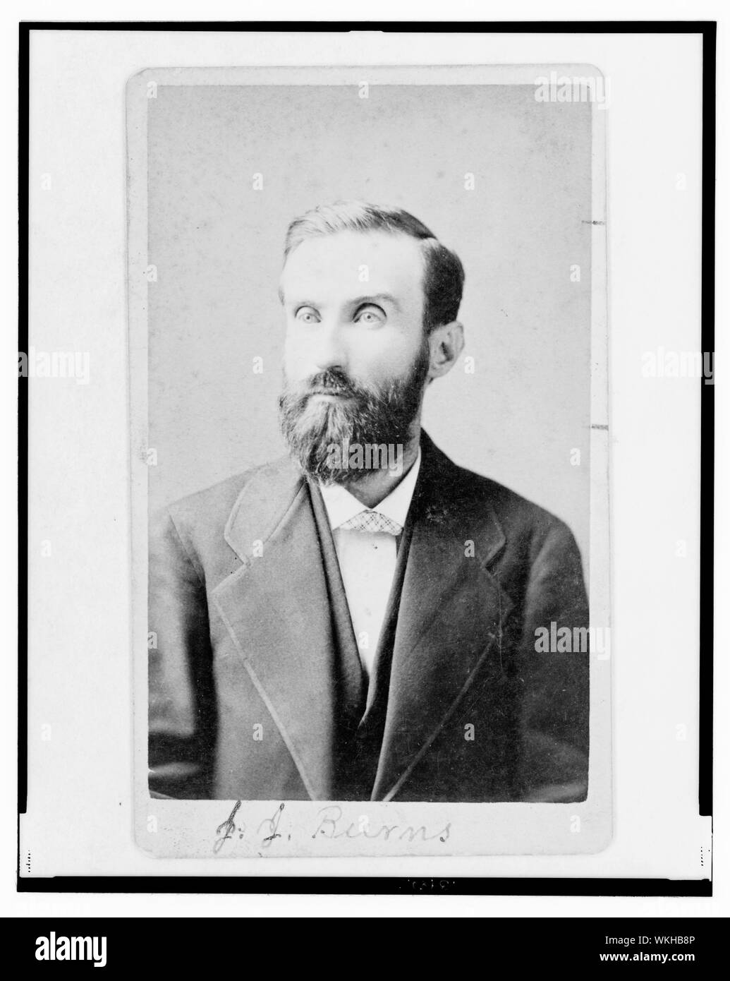 John J. Burns, mezza lunghezza verticale, rivolto verso sinistra Foto Stock