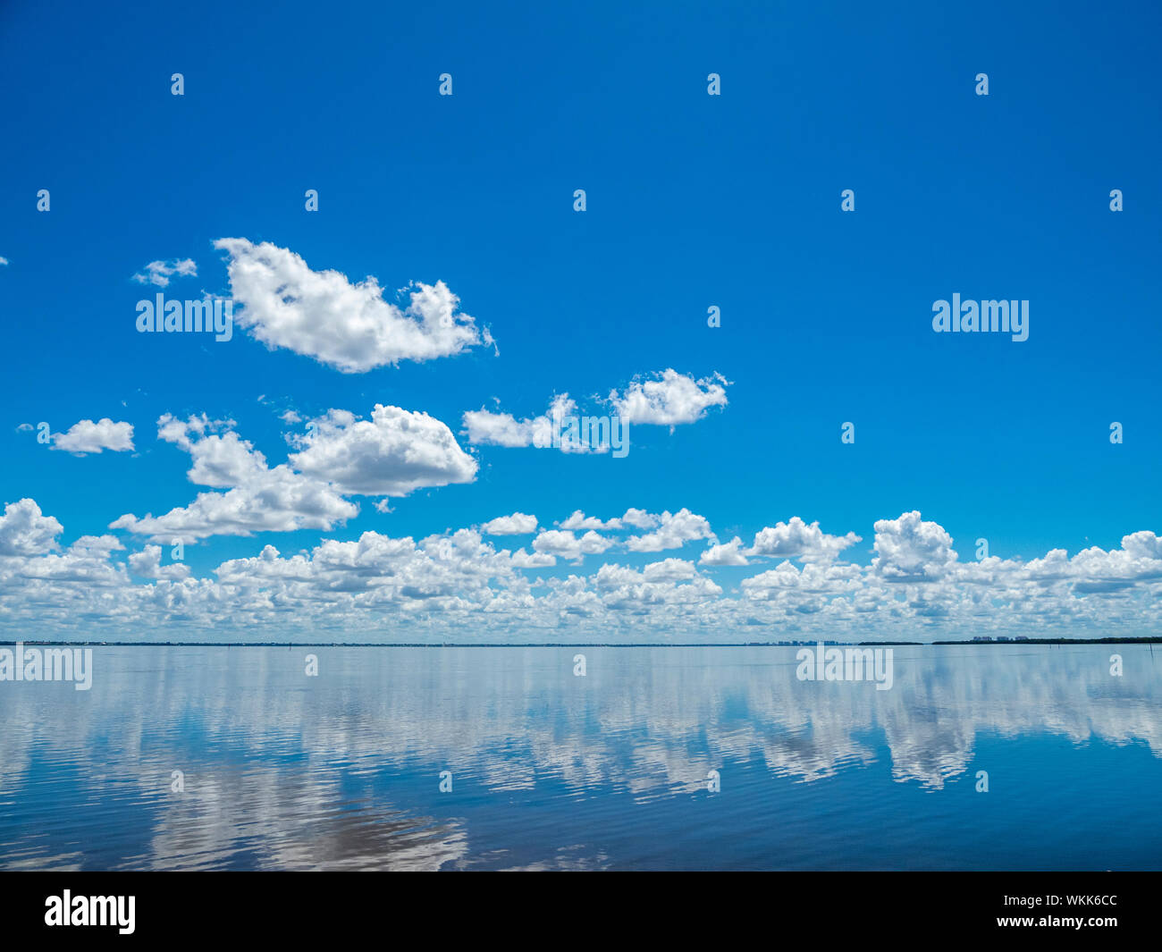 Il bianco delle nuvole in cielo blu che riflette in Sarasota Bay presi da Longboat Key nel sud-ovest della Florida Foto Stock