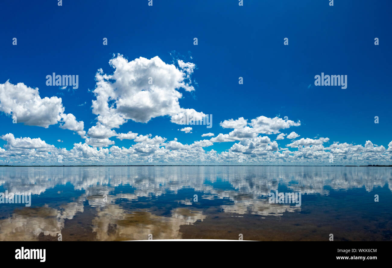Il bianco delle nuvole in cielo blu che riflette in Sarasota Bay presi da Longboat Key nel sud-ovest della Florida Foto Stock