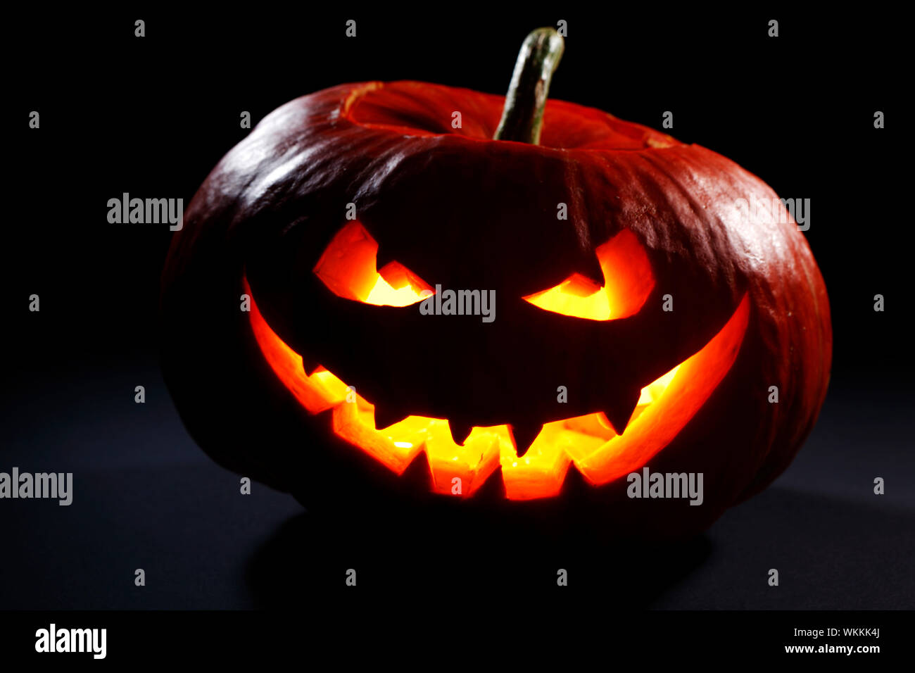 Zucca di Halloween jack testa lanterna con spaventoso faccia male su nero Foto Stock