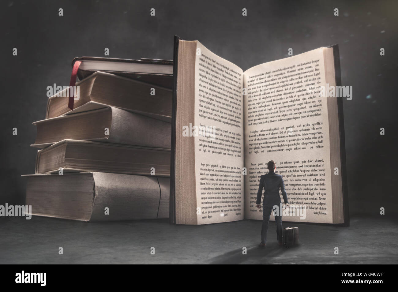 Immagine surrealista di imprenditore guardando il grande libro aperto nella camera oscura. Foto Stock