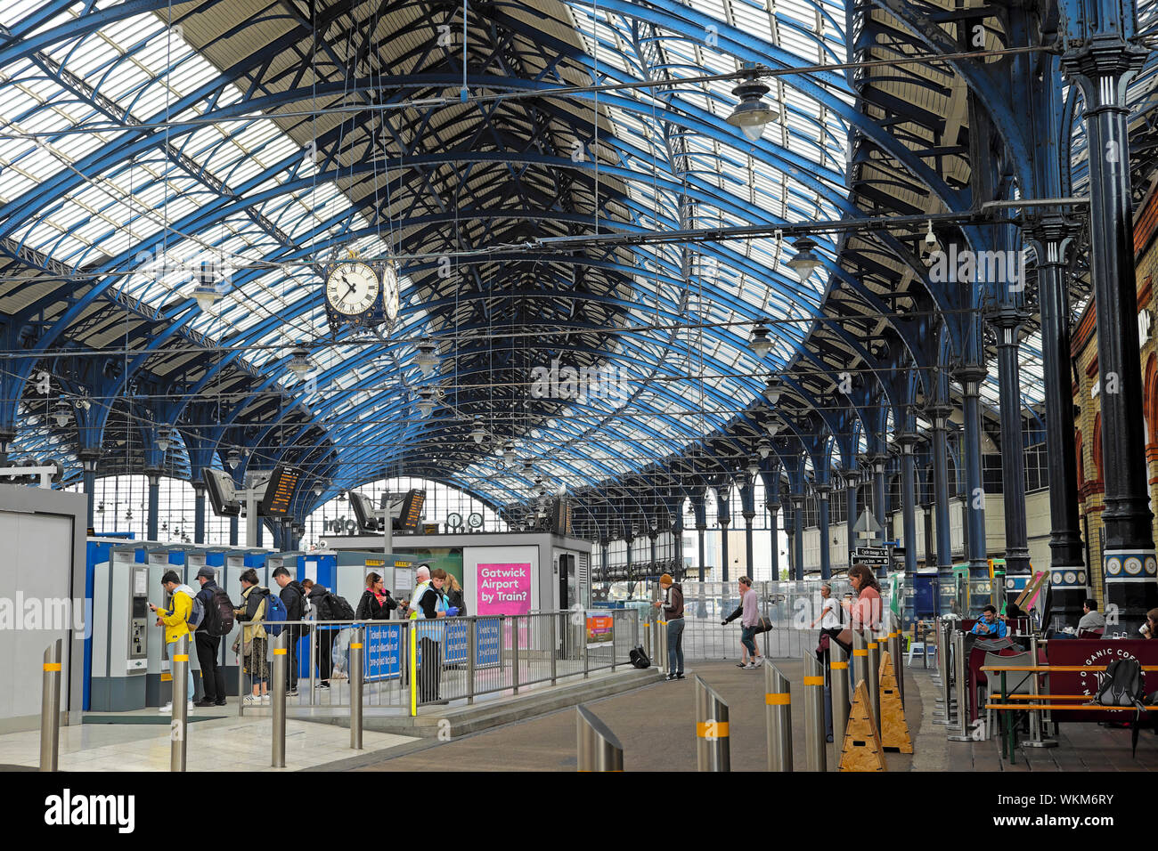 Stazione ferroviaria di Brighton treno capannone vista interna della struttura di tetto e persone che acquistano biglietti presso i distributori automatici di biglietti Inghilterra Gran Bretagna UK KATHY DEWITT Foto Stock