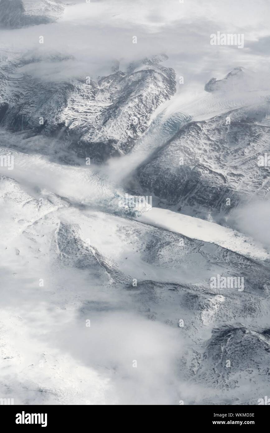 Vista dal piano sul ghiacciaio, paesaggi innevati delle montagne dal volo d'uccello, Groenlandia Foto Stock
