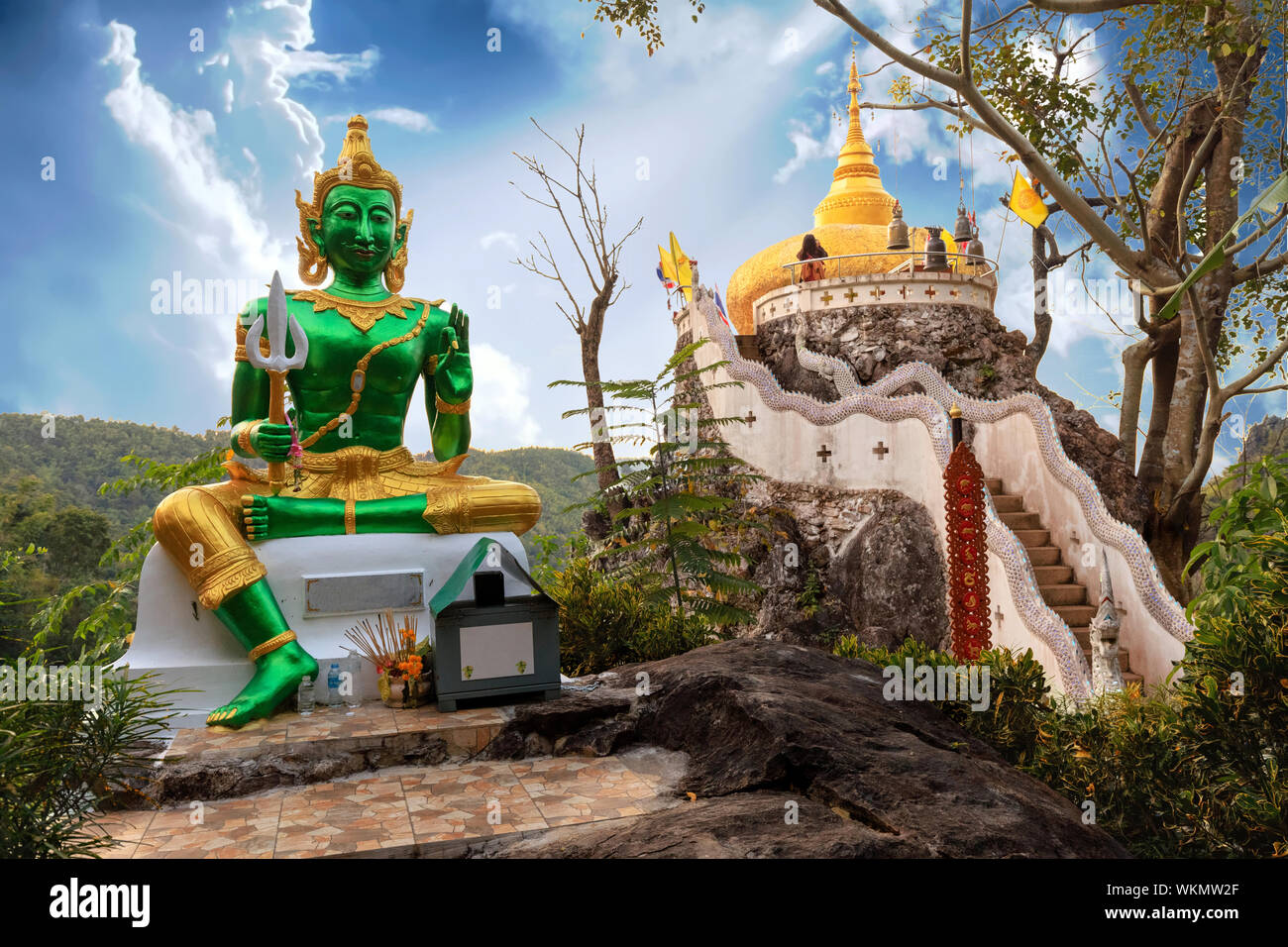 Golden statua del Buddha e la pagoda di Wat Phra That nel tempio Kwaen, Phrae provincia, Thailandia Foto Stock