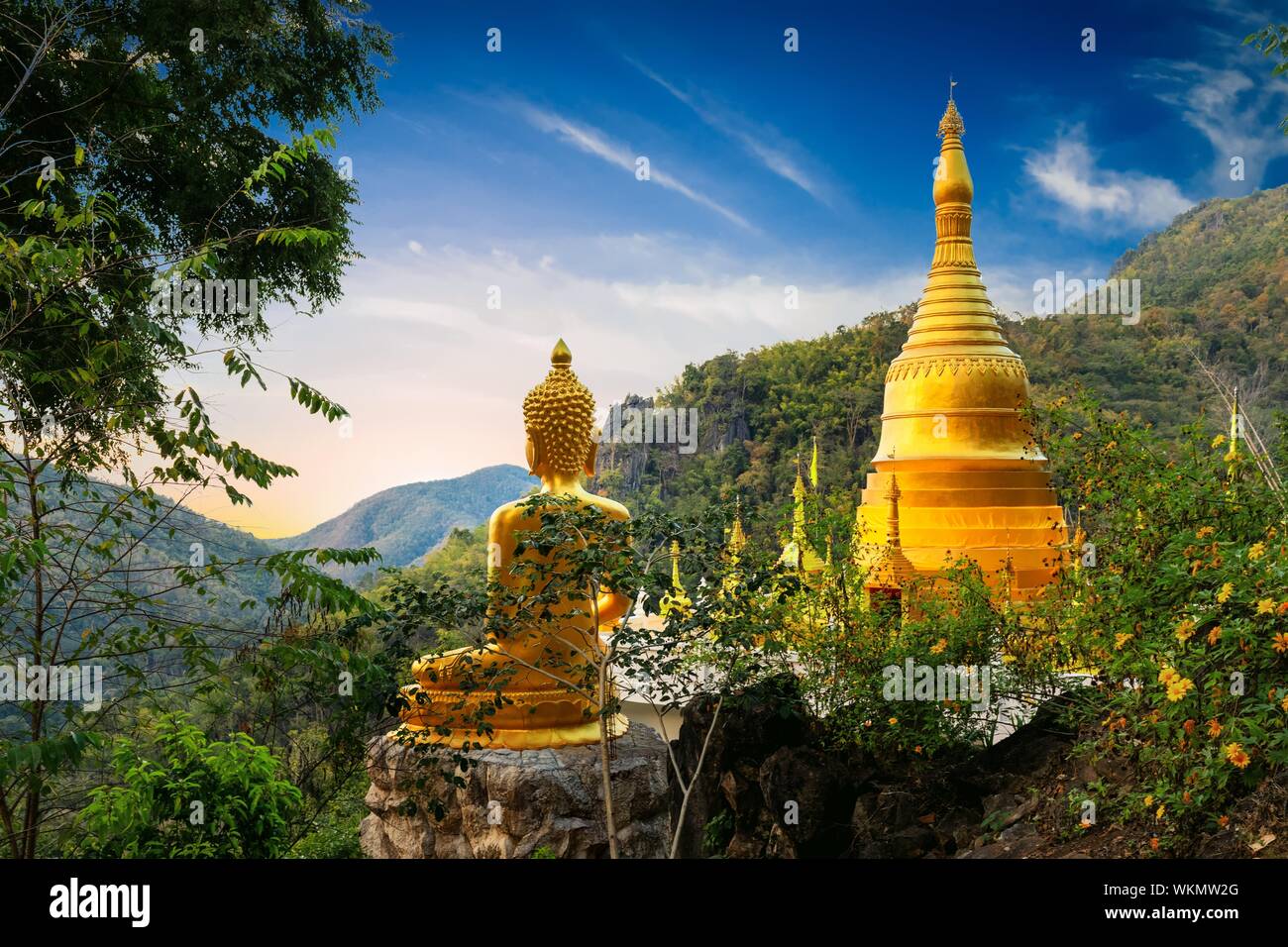 Golden statua del Buddha e la pagoda di Wat Phra That nel tempio Kwaen con punto di vista, Phrae provincia, Thailandia Foto Stock