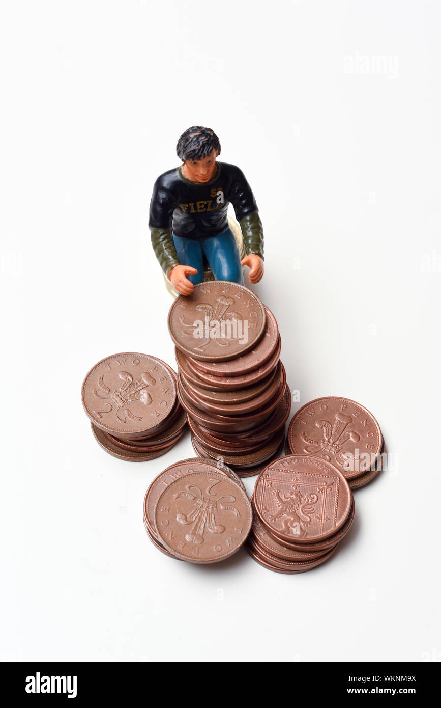 Rendendo il risparmio di denaro e di rendere il concetto di denaro. L'uomo si siede su una pila su monete Foto Stock