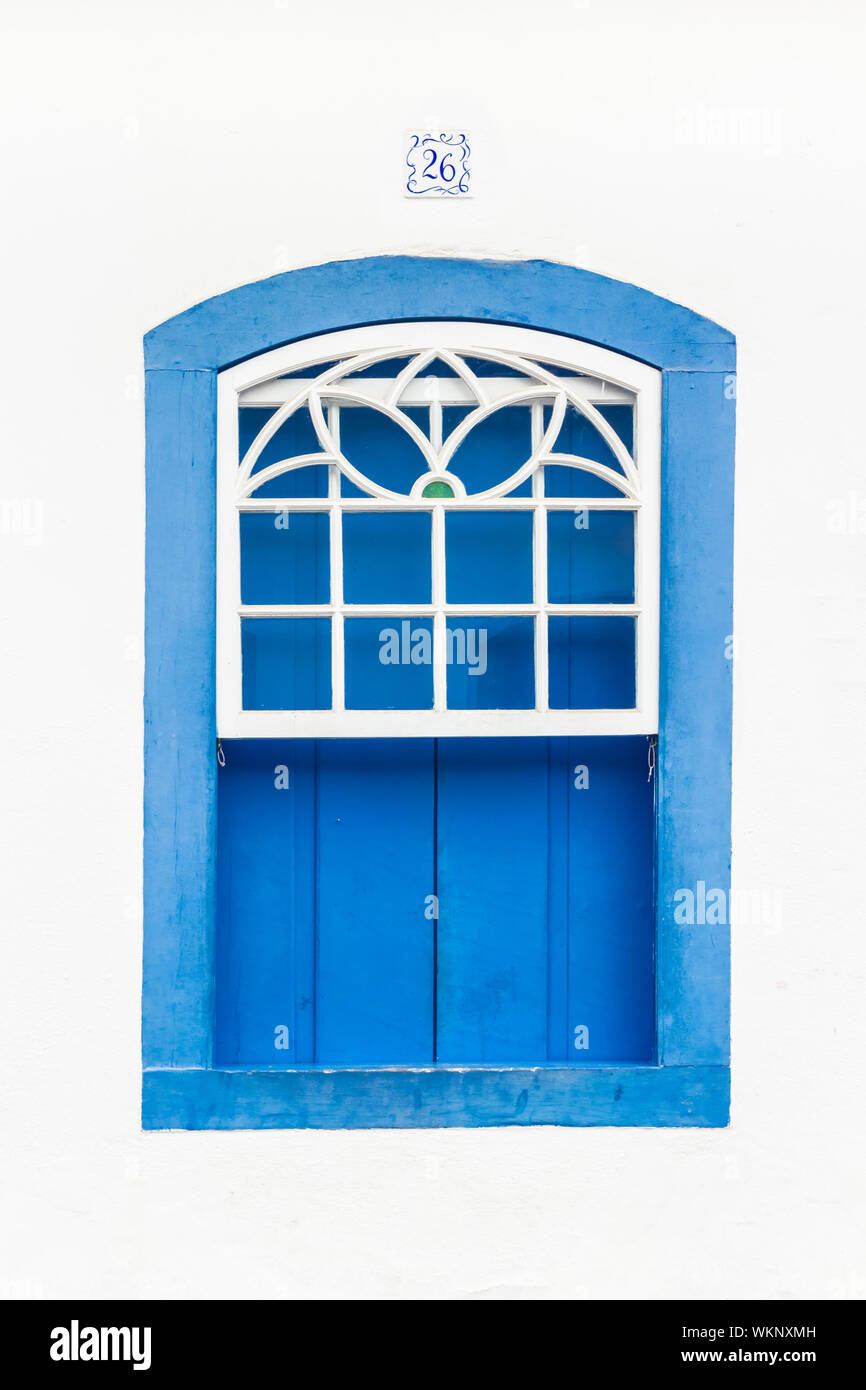 Decorative, coloniale, blu, vintage, finestra su una parete bianca a Paraty (o Parati), Brasile. Foto Stock