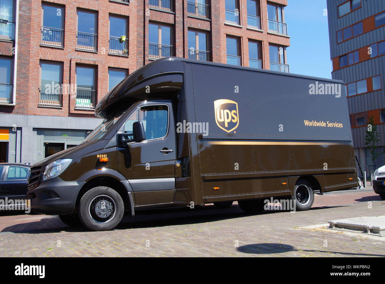 Almere Poort, Flevoland, Paesi Bassi - 13 Maggio 2016: consegna UPS carrello parcheggiato a lato della strada di fronte ad un edificio. Foto Stock