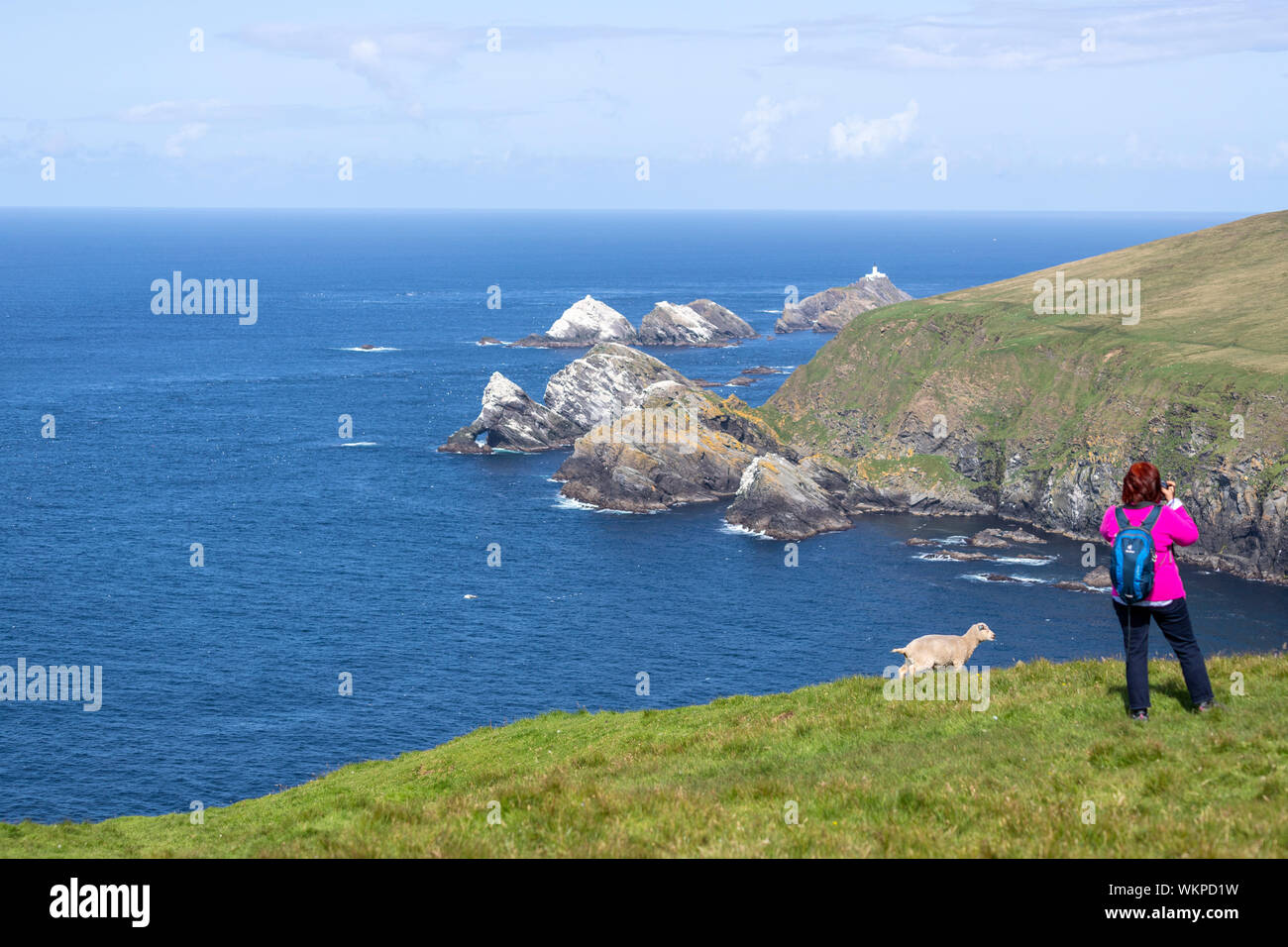 I turisti che scattano foto alle clifs e al faro di Muckle Flugga dalla Unst Hermaness National Nature Reserve, Shetland, Scozia, Regno Unito Foto Stock