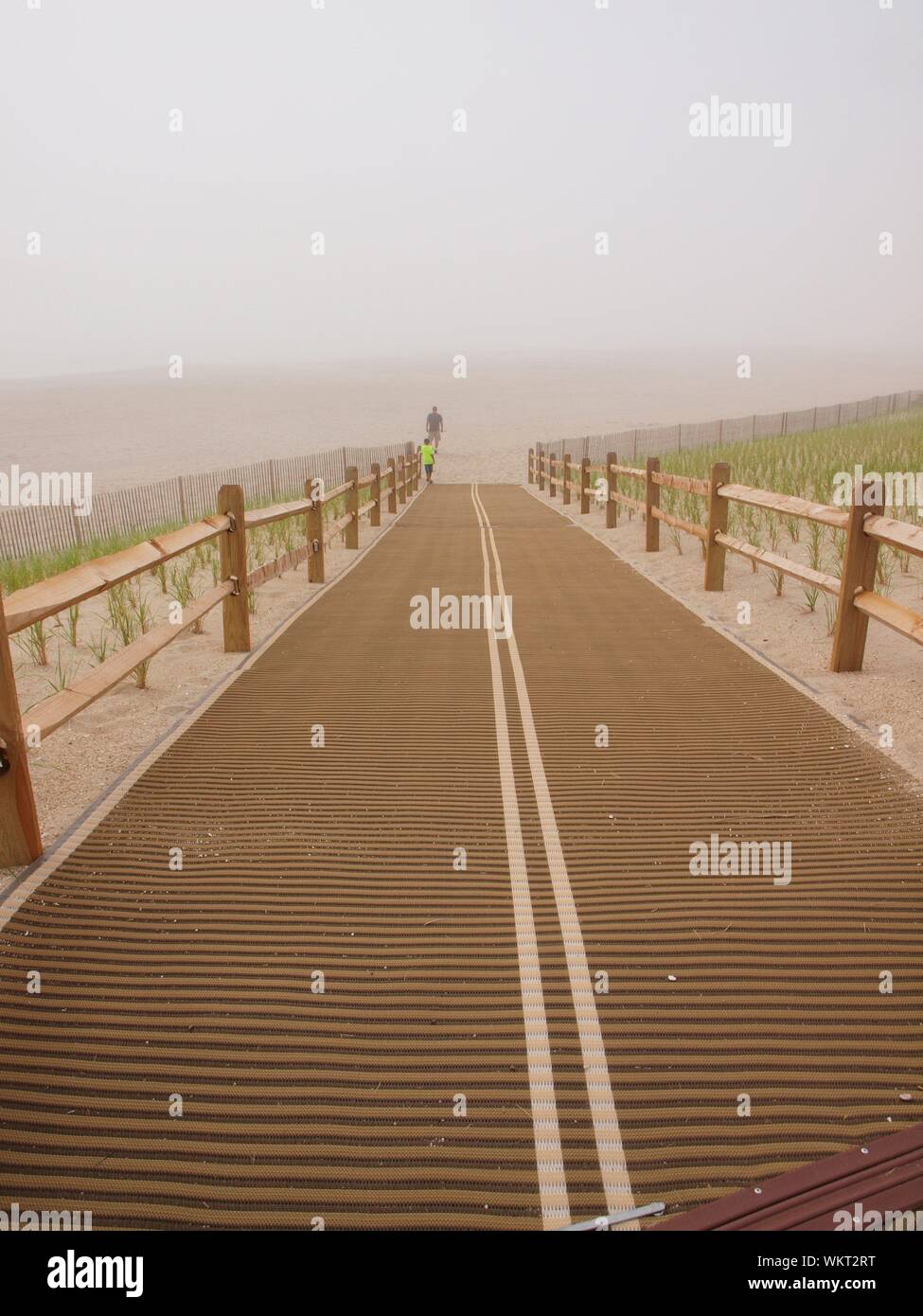 Spiaggia deserta accedere sul giorno nuvoloso in New Jersey. Spiaggia quasi deserta scena con solo due persone in distanza. Foto Stock