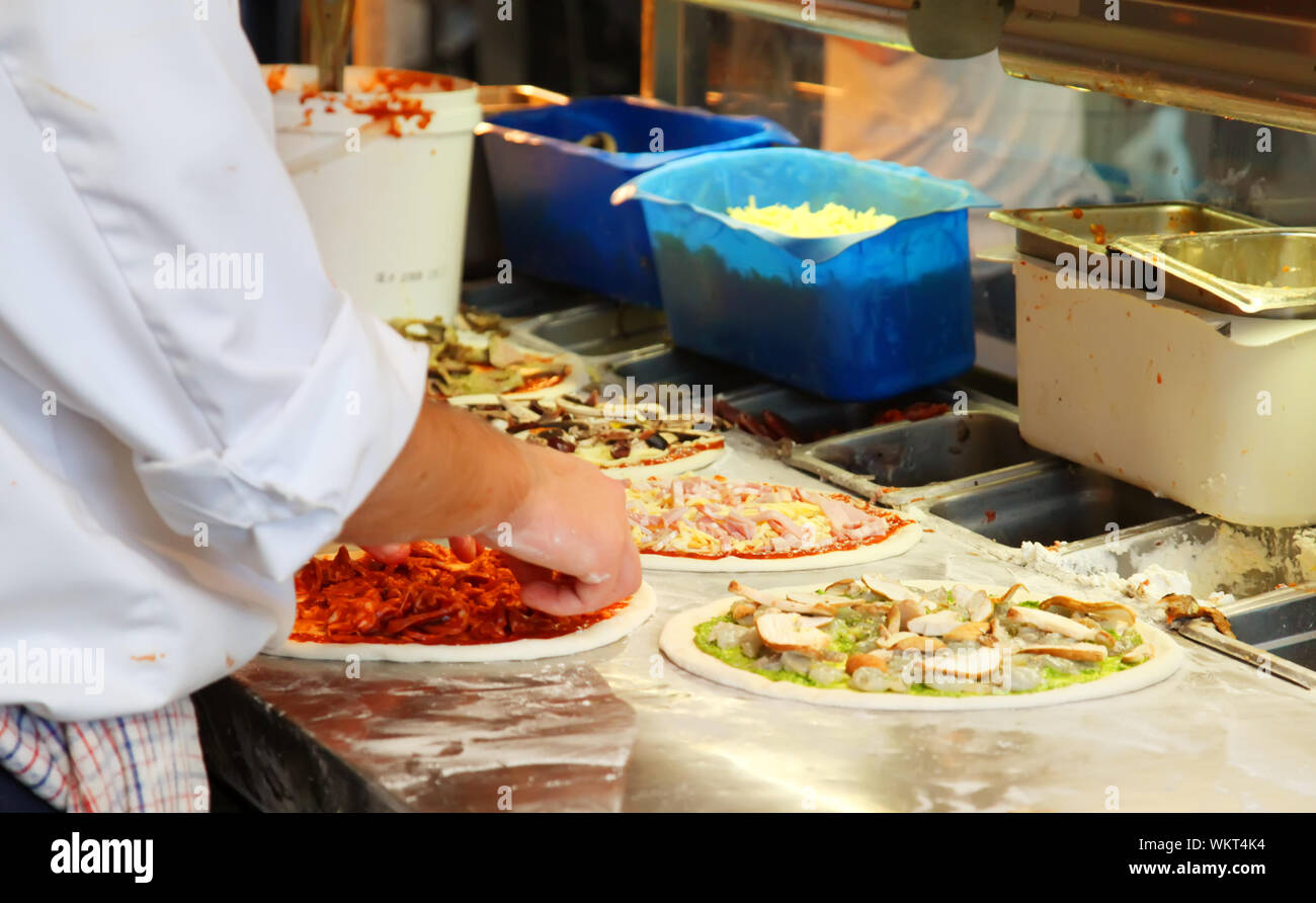 Lo Chef rendendo un assortimento di pizze in un ristorante Foto Stock