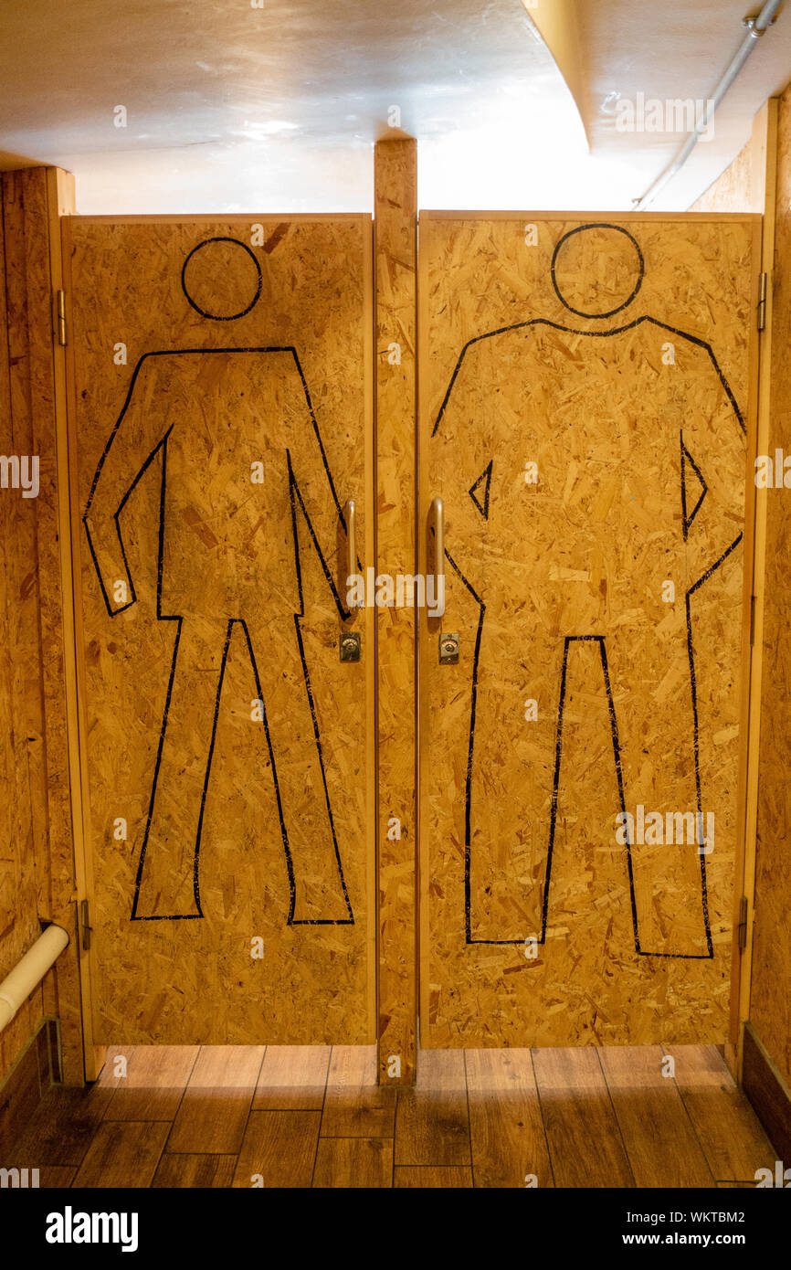 Disegnate il contorno di un uomo sul chip di legno porte in un gents wc Foto Stock