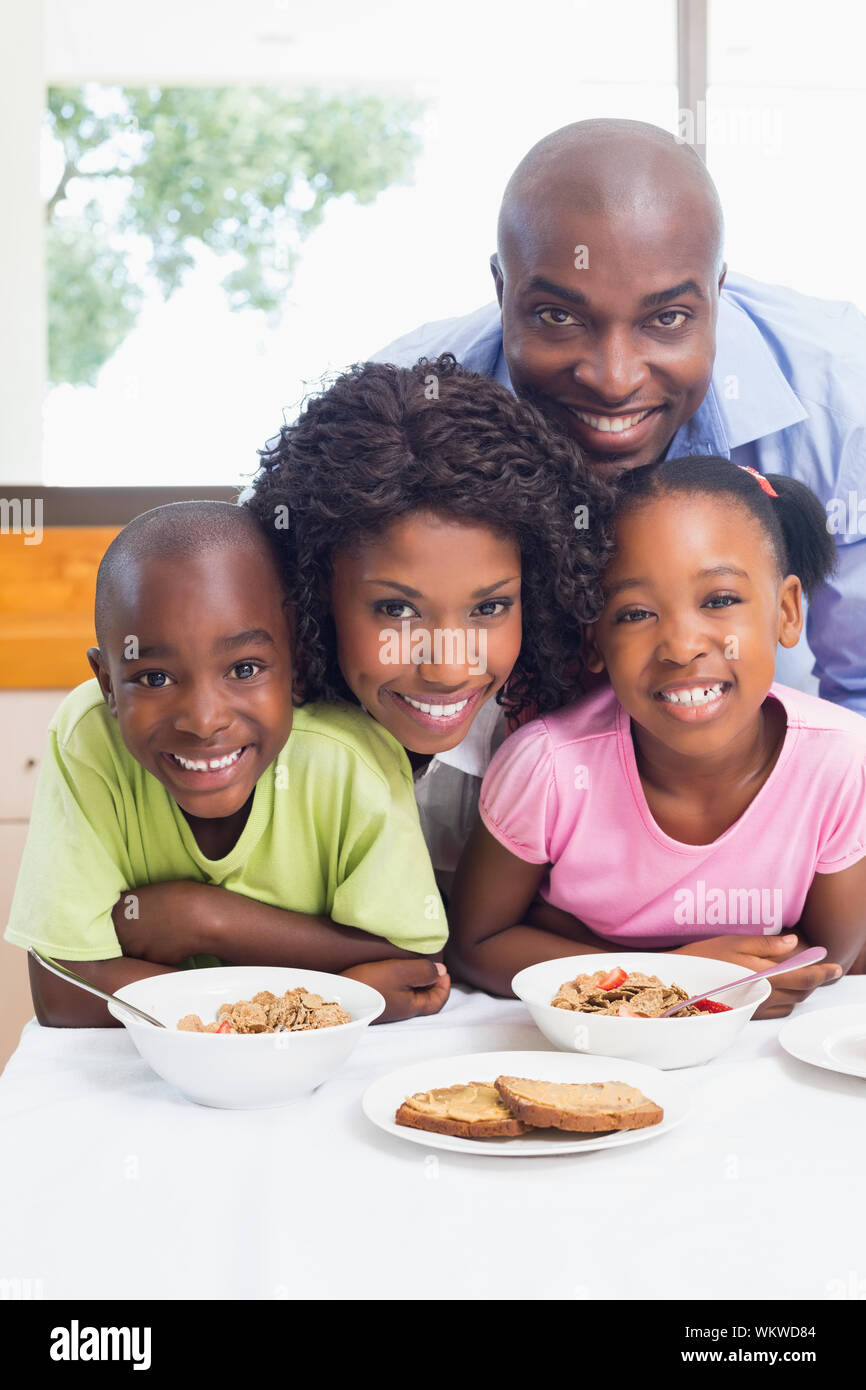 La famiglia felice avente insieme per la prima colazione di mattina a casa in cucina Foto Stock