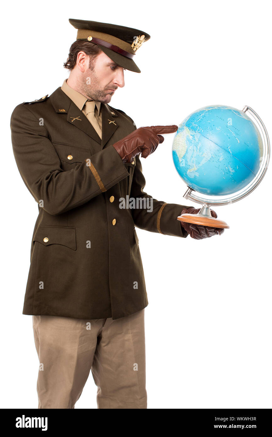 Giovane ufficiale militare azienda mappa del globo e indicante Foto Stock