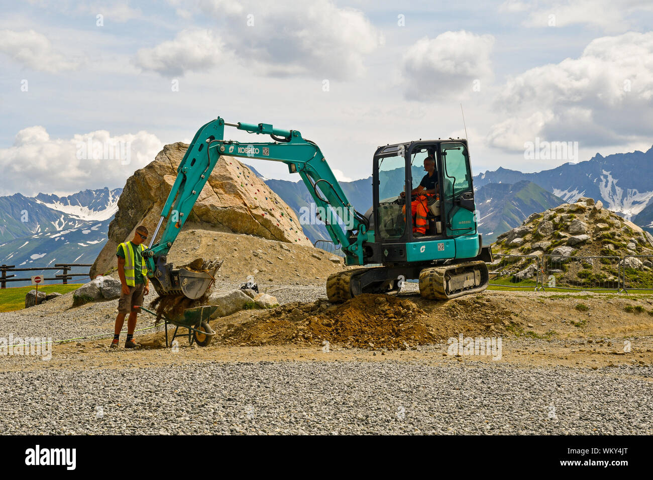 Gli addetti alla manutenzione di massa in movimento con un mini escavatore al Pavillon funivia di Skyway Monte Bianco in estate, Courmayeur, Aosta, Italia Foto Stock