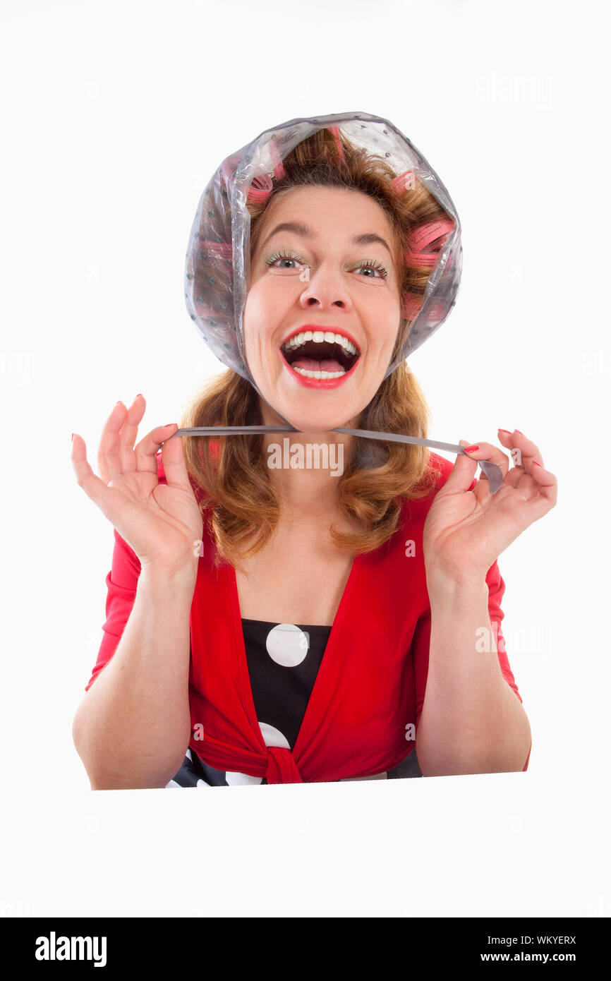 Felice di mezza età della donna in rosso con i capelli rulli - isolato su bianco Foto Stock