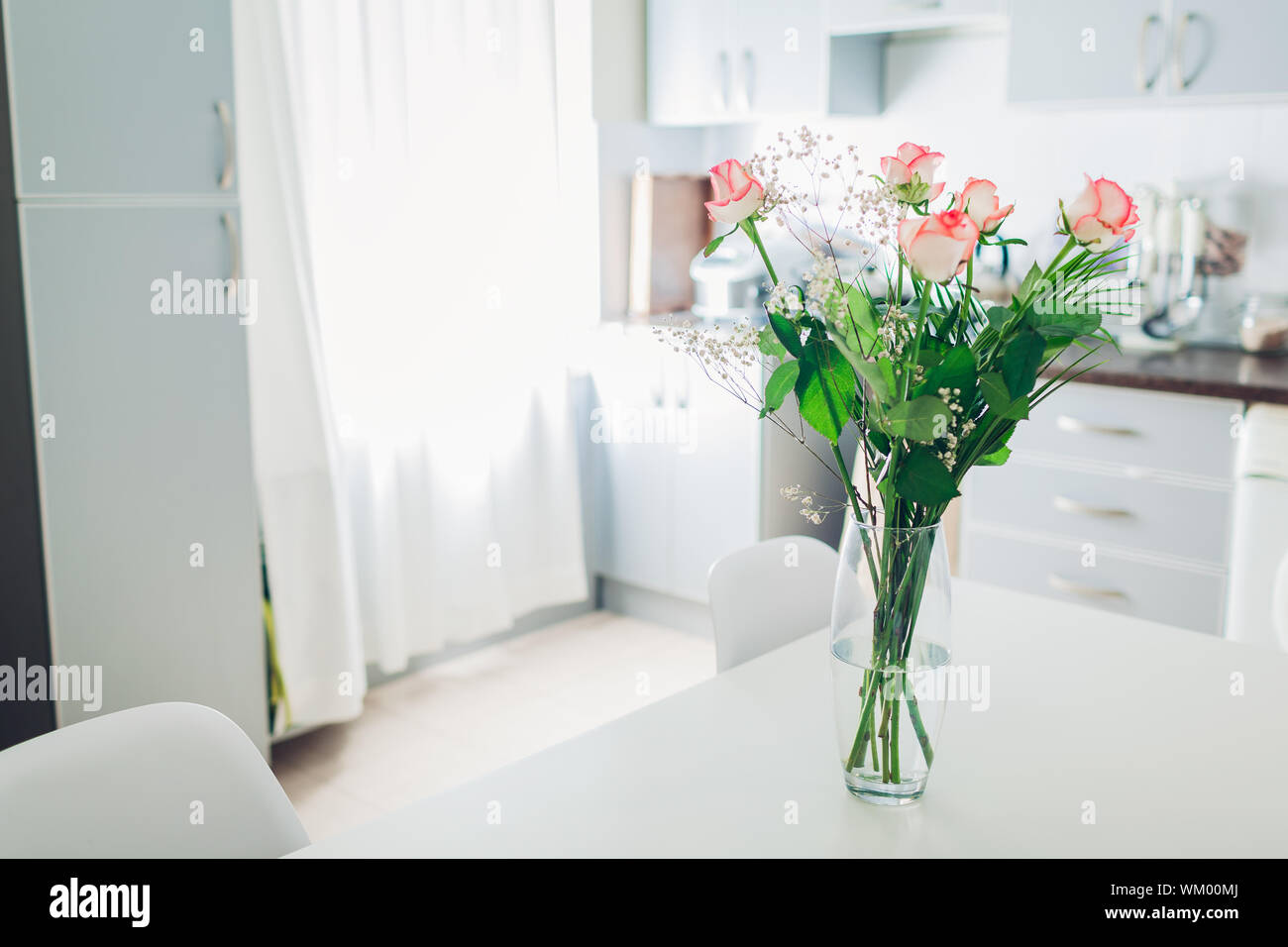 Mazzo di rose sulla cucina. Moderna cucina design. Interno della cucina decorata con fiori. Foto Stock
