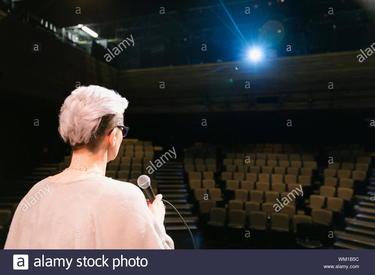 Femmina altoparlante ispiratore praticando sul palco in auditorium vuoto Foto Stock