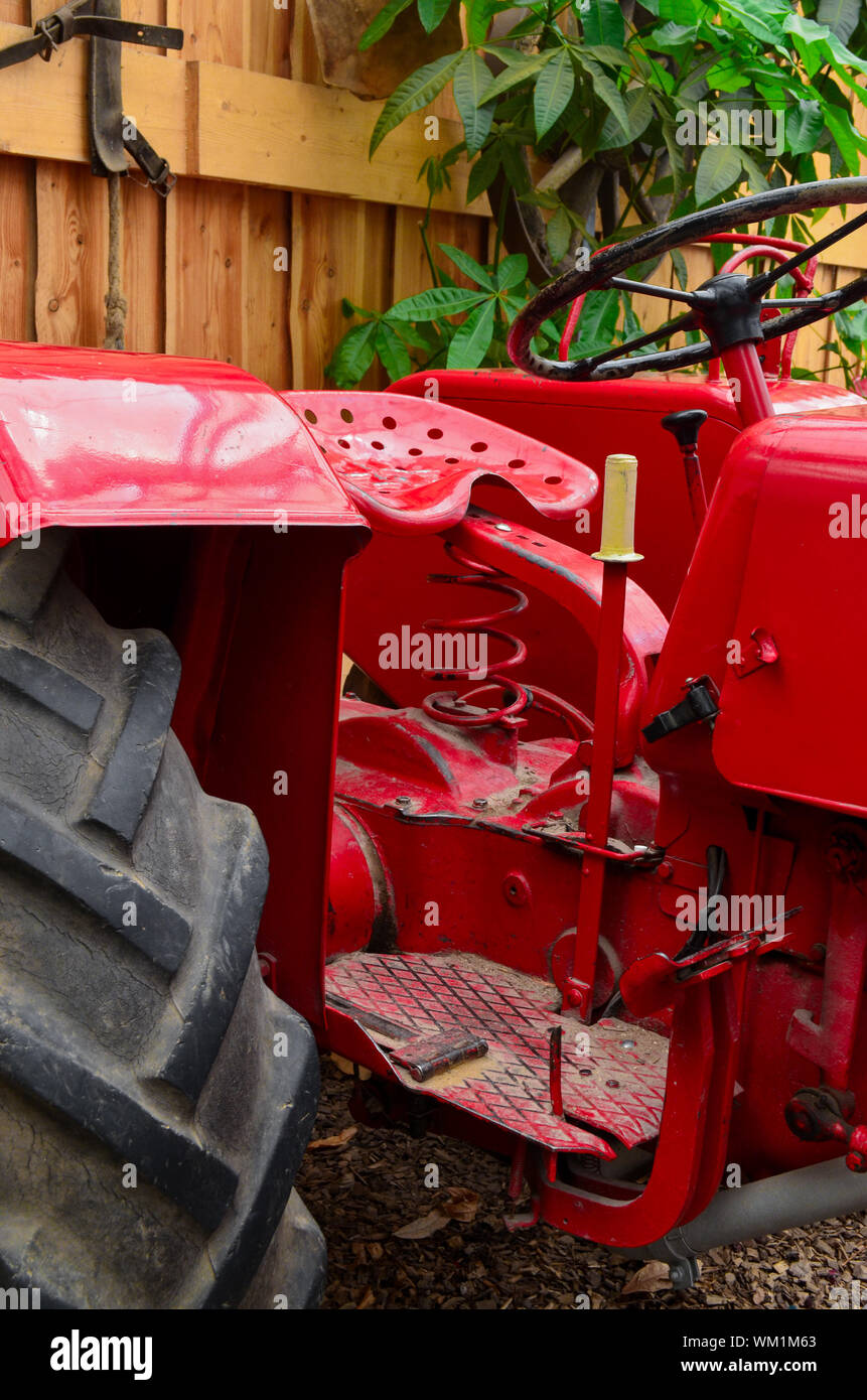 Trattore rosso parcheggiato in un granaio Foto Stock
