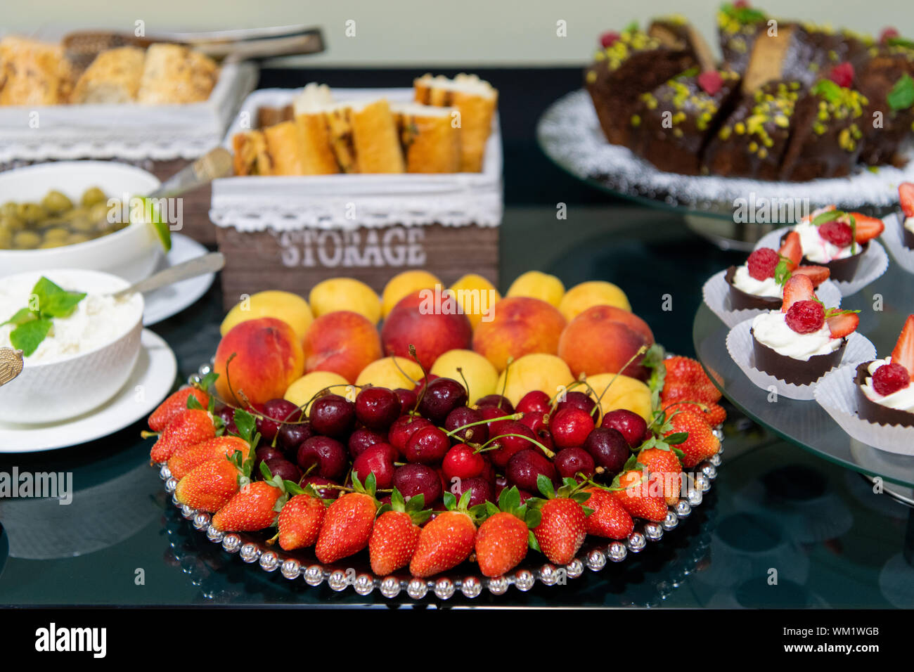 Una sana frutta, Ciliegie Fragole Arance Mele Pesche Albicocche sul tavolo vicino. Foto Stock