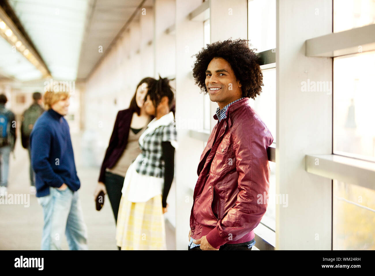 Un americano africano maschio con amici parlando in background Foto Stock