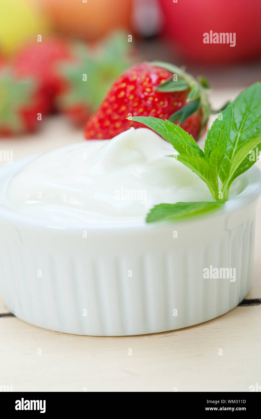 Organici di yogurt greco e fragole bianco su tavola in legno rustico Foto Stock