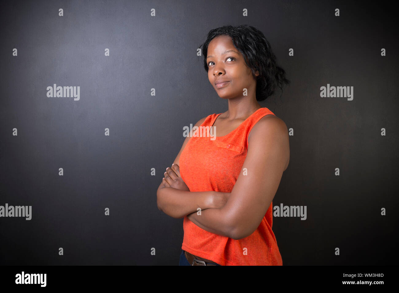 Sud Africano o americano africano insegnante di donna su chalk nero lo sfondo della scheda Foto Stock