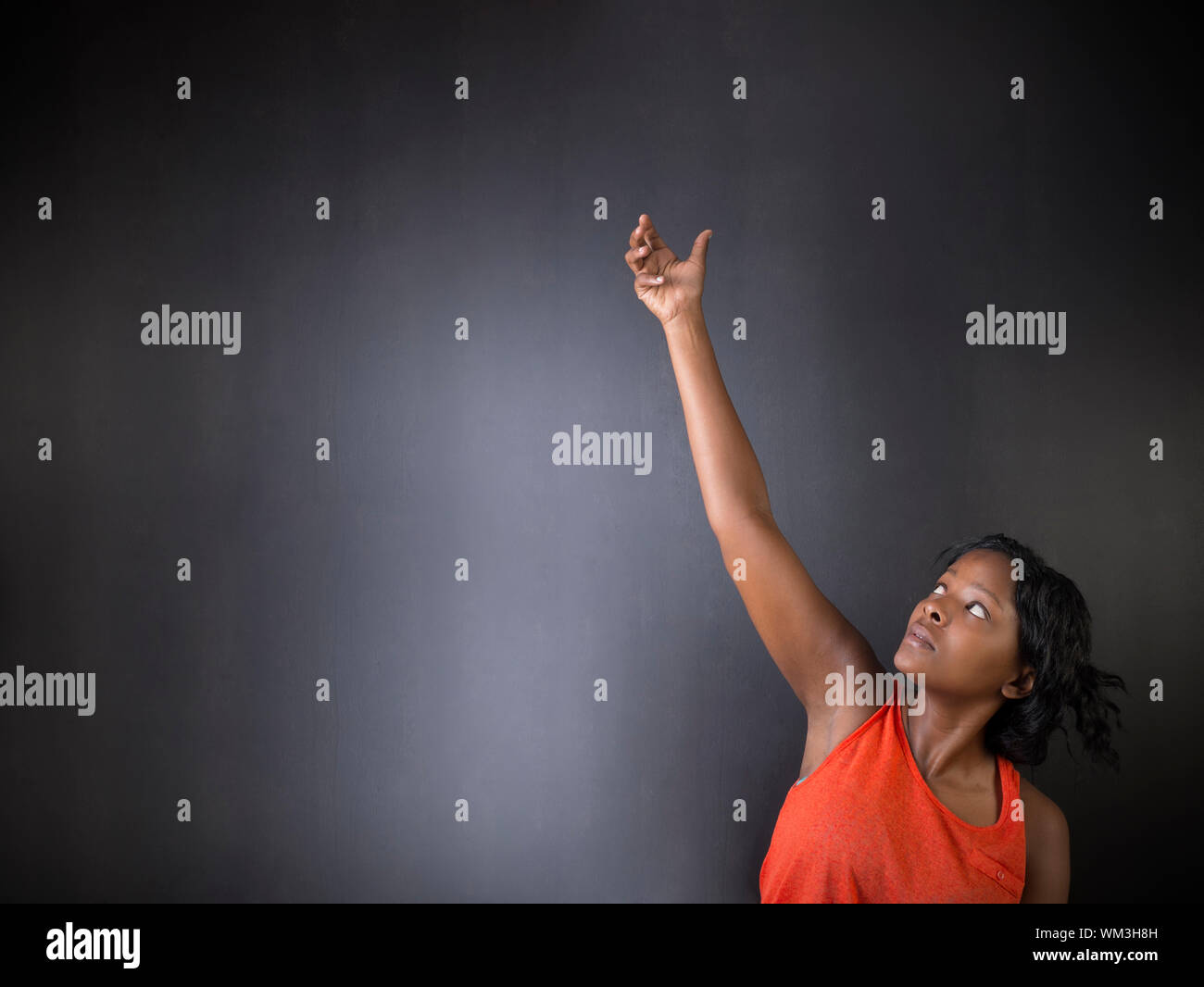 Sud Africano o americano africano insegnante di donna su chalk nero lo sfondo della scheda Foto Stock