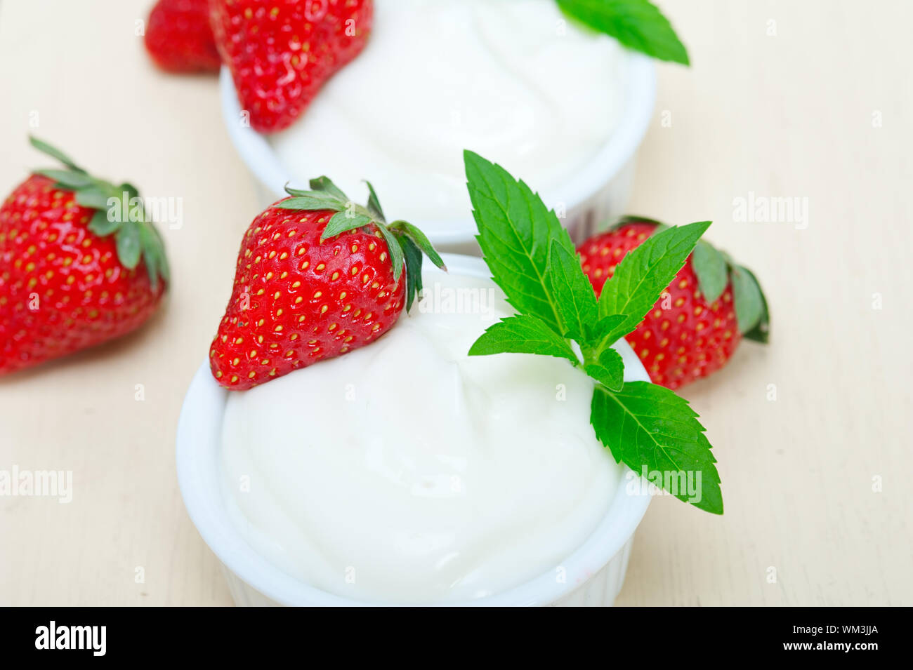 Organici di yogurt greco e fragole bianco su tavola in legno rustico Foto Stock