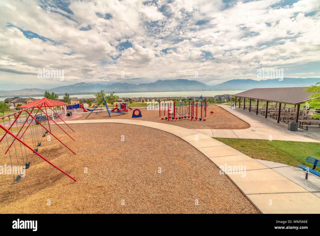 Parco con parco giochi per bambini e un padiglione per picnic sotto un cielo nuvoloso Foto Stock