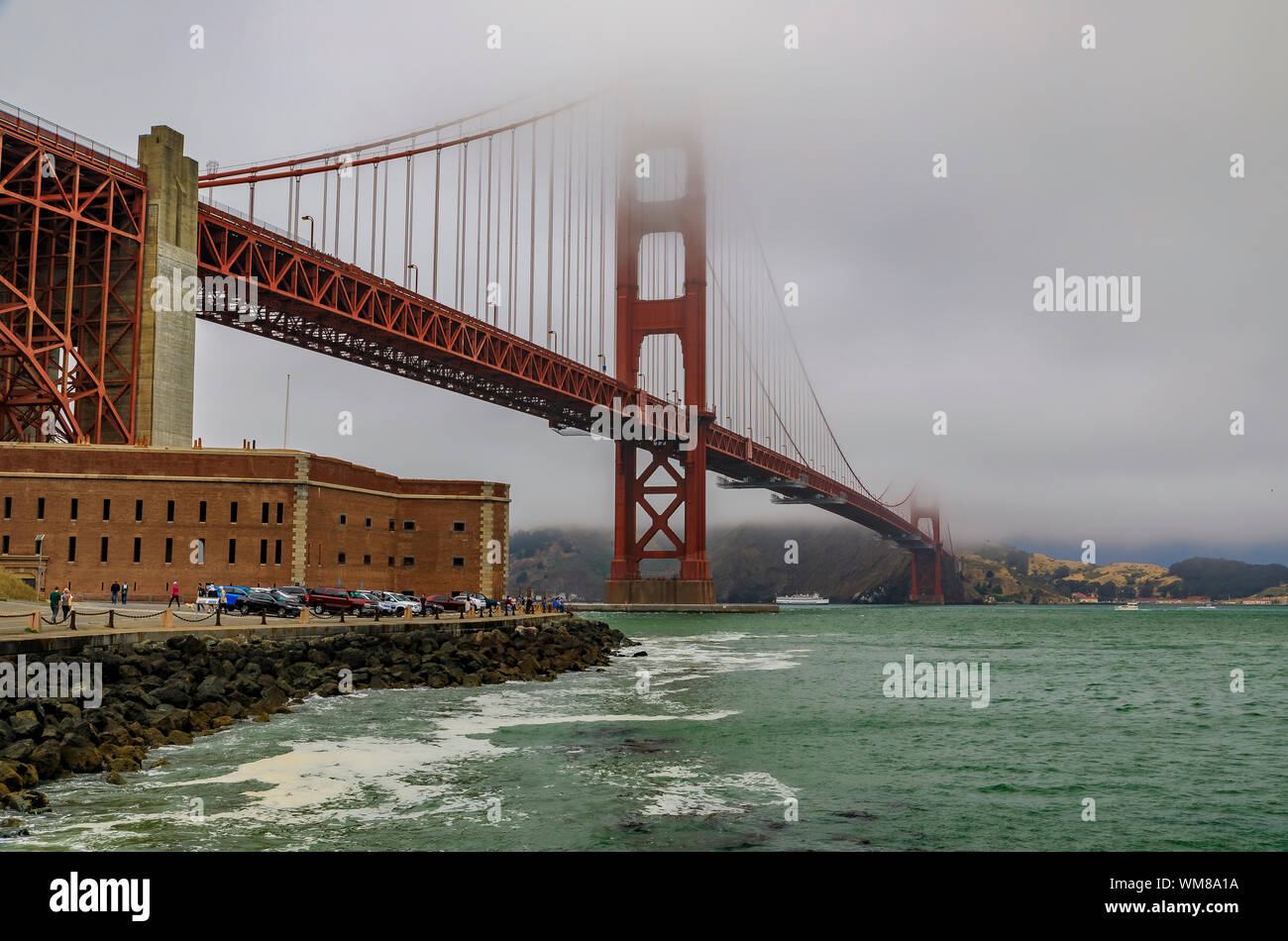 Il famoso Golden Gate bridge su un nuvoloso giorno di estate con bassa appendere la laminazione di nebbia a San Francisco, California Foto Stock