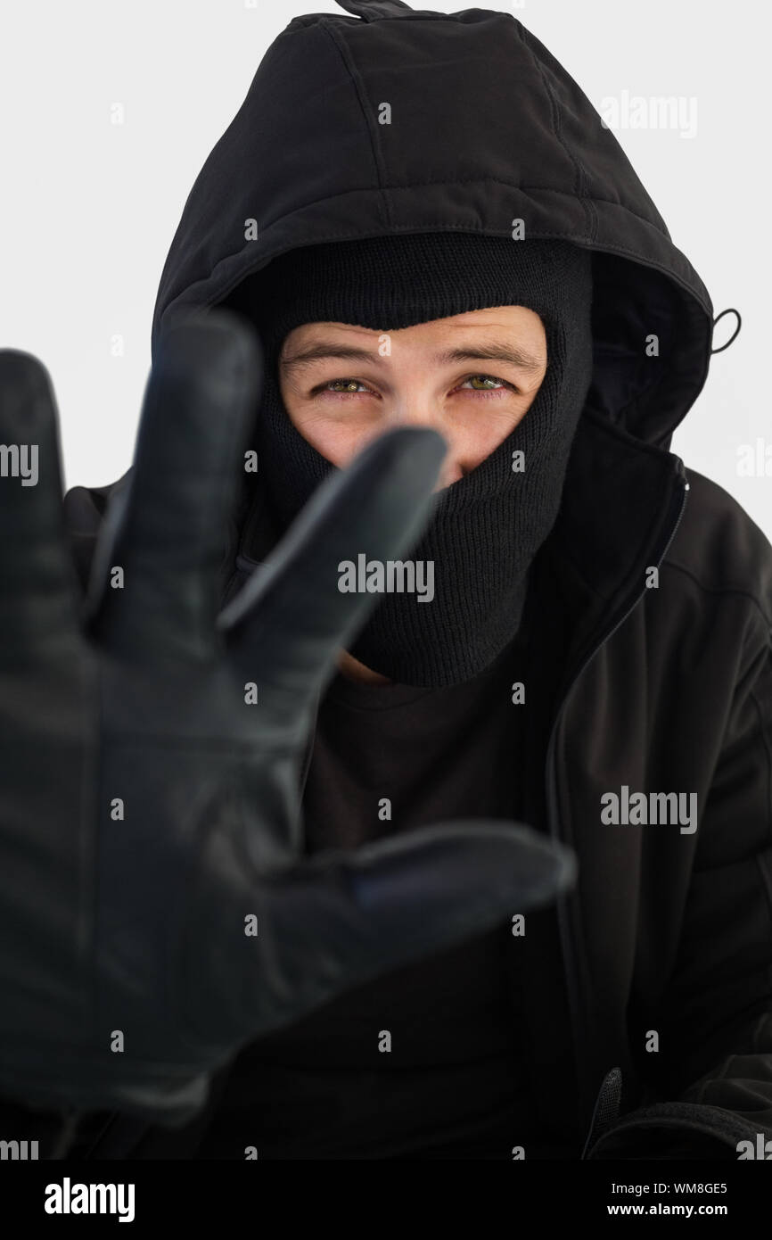 Ritratto del ladro che indossa un passamontagna su sfondo bianco Foto stock  - Alamy