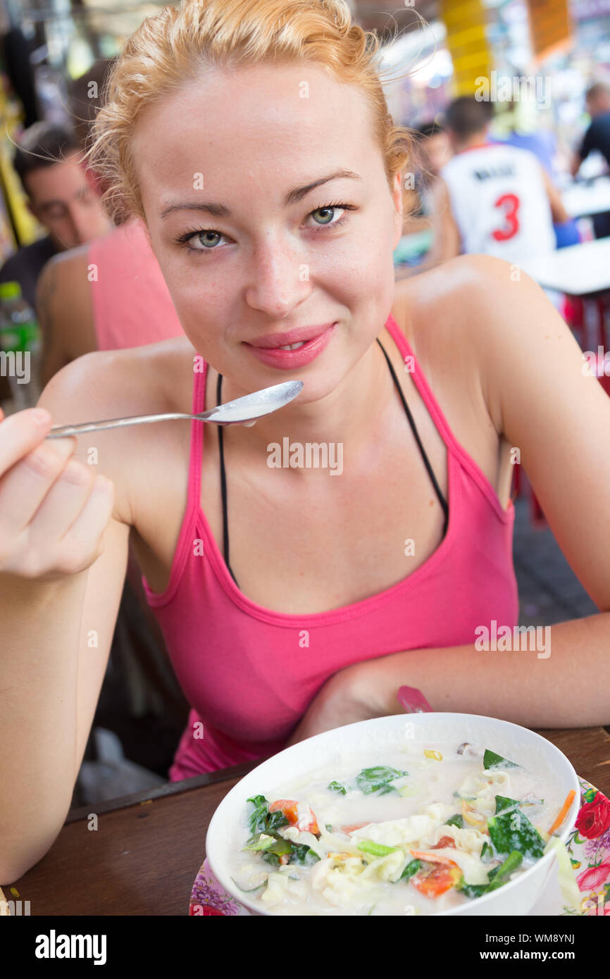 Traveler mangiare tradizionale tailandese Tom Yum zuppa. Foto Stock