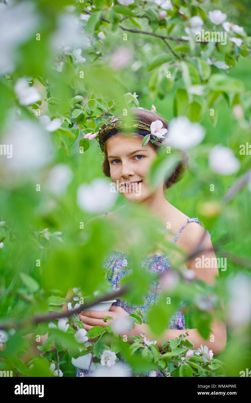 Adorabile ragazza in fioritura melo giardino sulla giornata di primavera Foto Stock