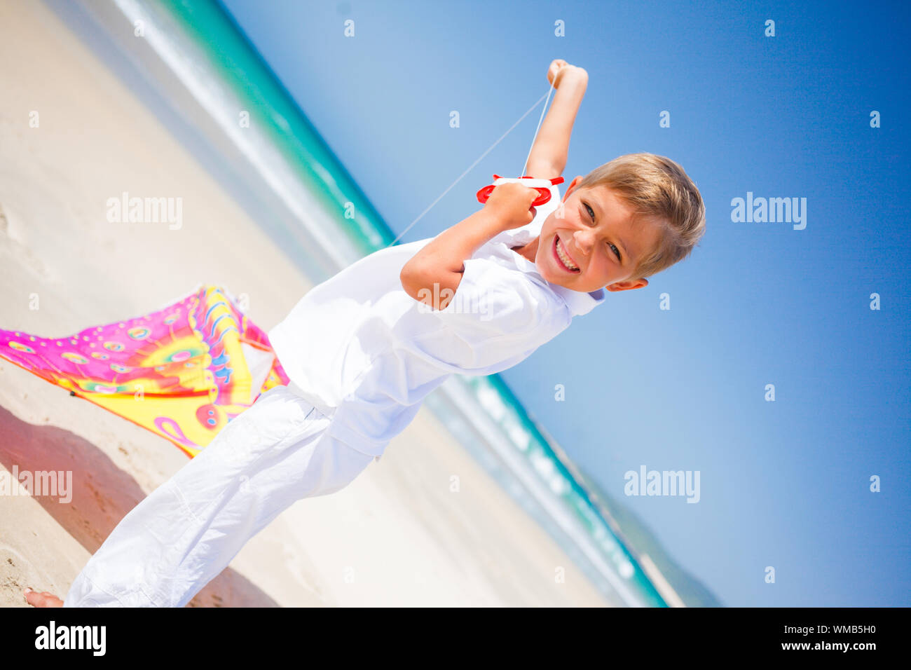 Vacanze estive - Molto carino boy battenti kite beach all'aperto. Foto Stock