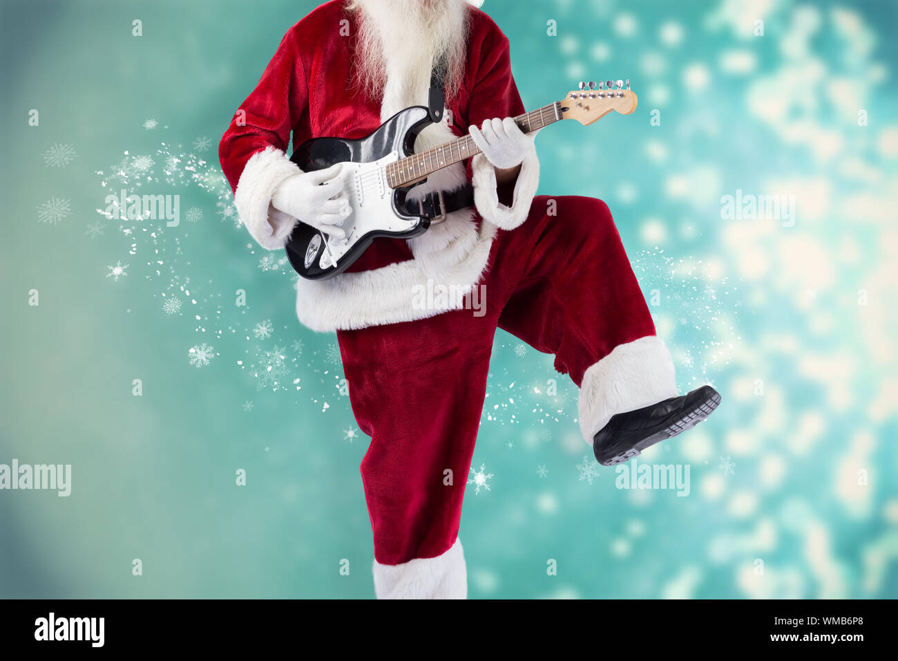Babbo Natale ha divertimento con una chitarra contro il disegno luci  scintillanti su blu Foto stock - Alamy